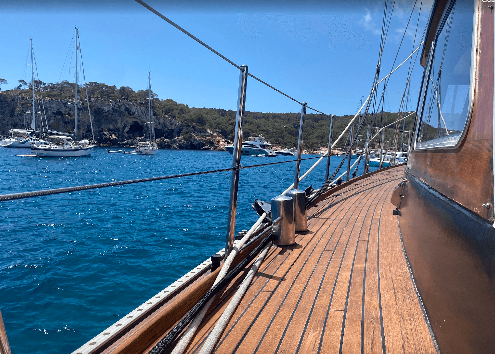 Il ponte in teak di SV Iron Monkey presso un ancoraggio soleggiato a Maiorca